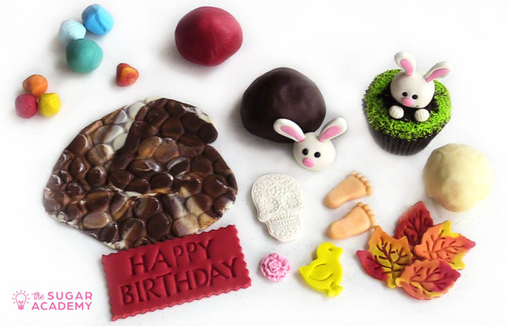 Modeling chocolate and candy clay decorations including a bunny, feet, leaves, and skull.